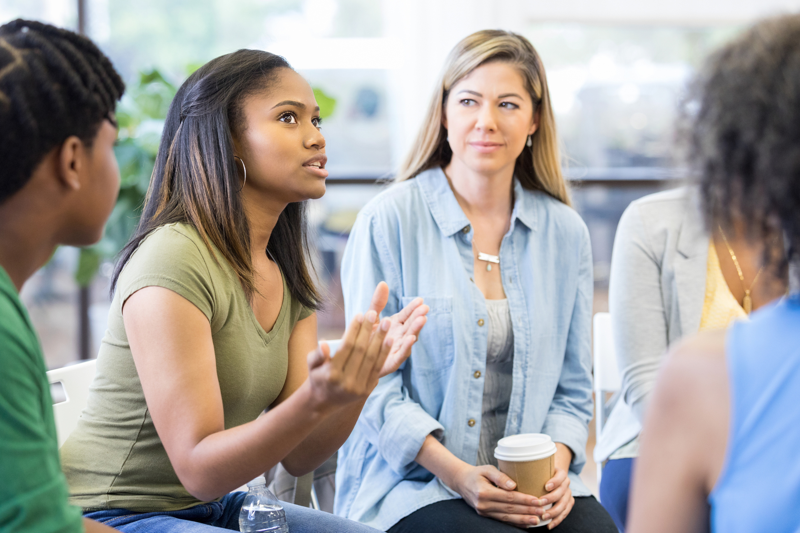 Everybody in therapy group looks at teen girl